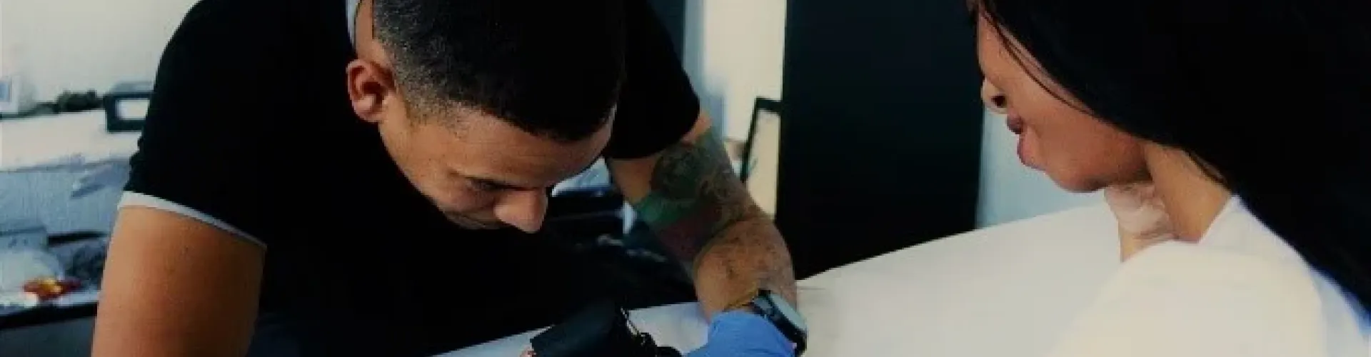 A person giving someone a tattoo