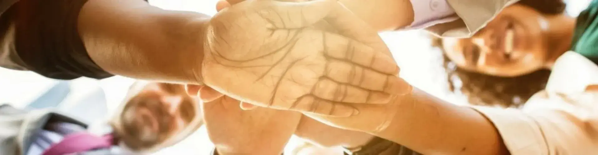 A group of people huddling in their hands