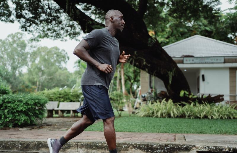 Man in grey shirt and black shorts running
